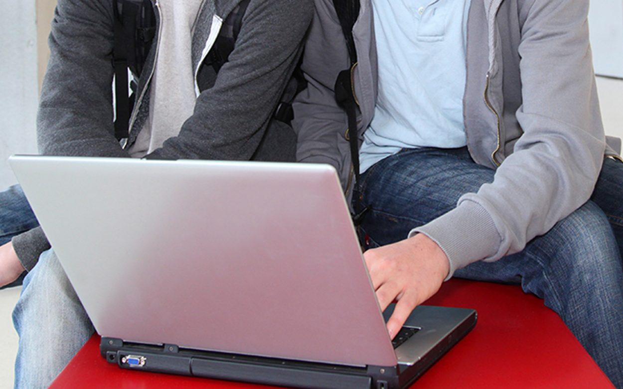 Two boys looking at a laptop computer