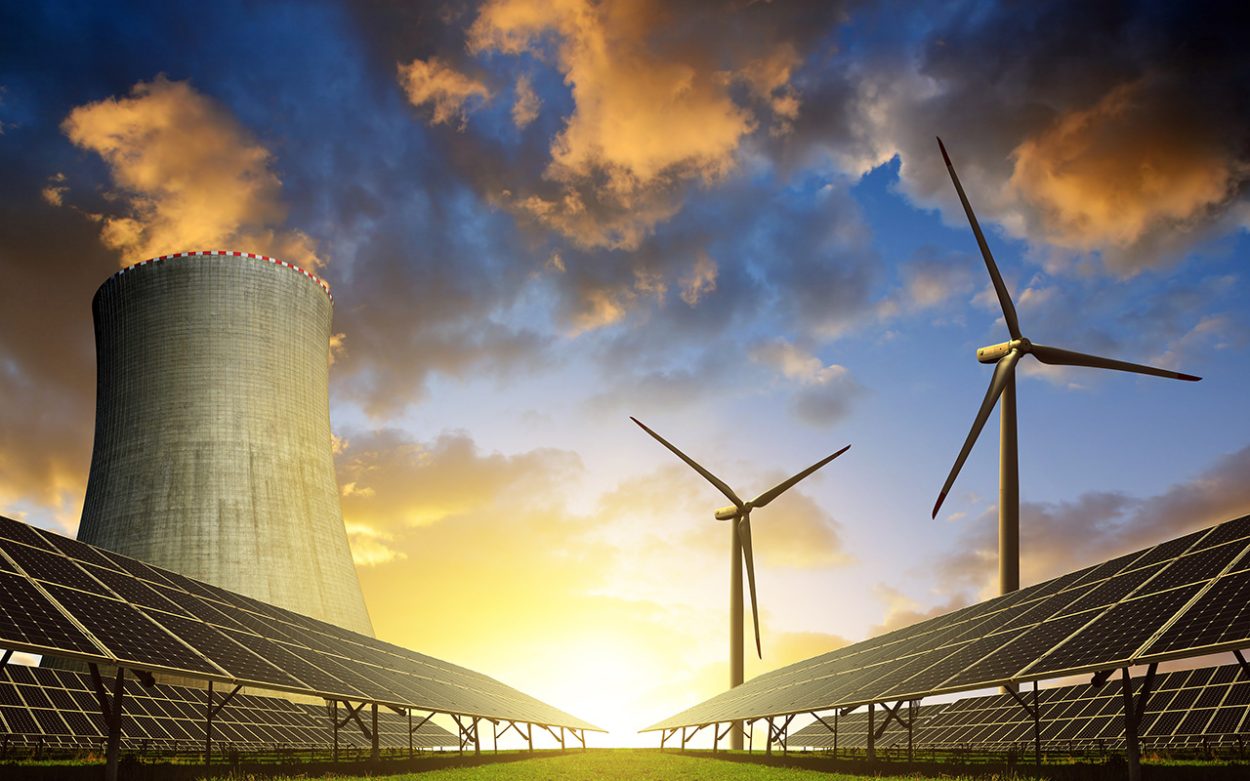 Solar energy panels, wind turbines and nuclear power plant at sunset.