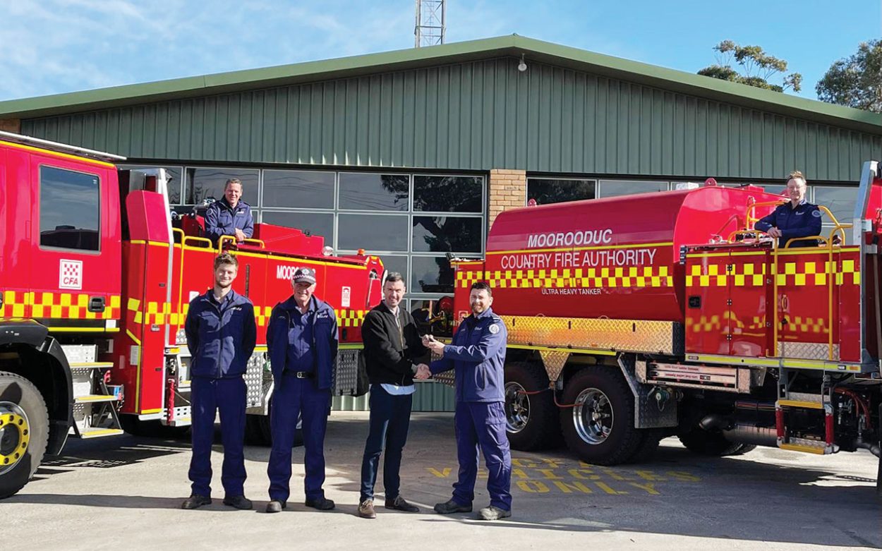 Tanker handover: At the tanker handover to Moorooduc Fire Brigade are Geoff Goding (on the truck at left), Tom Winkle, former captain Nev Jones, Tom McIntosh MP, Justin Newson, and Megan McDonald (in truck at right). Picture: Supplied